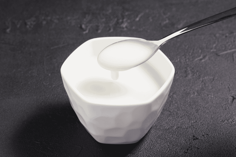 Sữa chua không đường chứa lactic acid — một AHA tự nhiên giúp tẩy tế bào chết hóa học nhẹ nhàng, làm sáng đều màu da