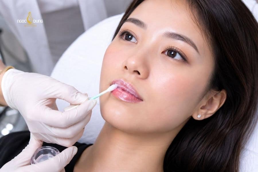 Tiến hành sát khuẩn và ủ tê môi trước khi khử thâm